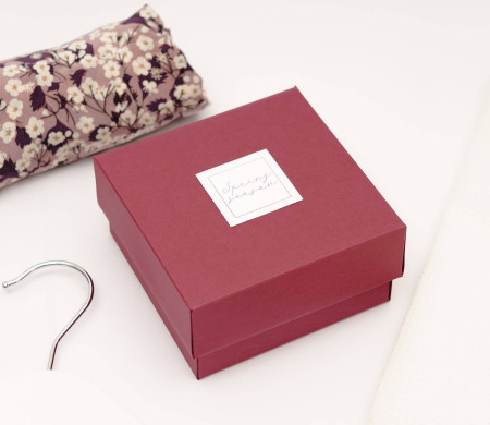 Small, lined burgundy box for organizing personal possessions and clothing.