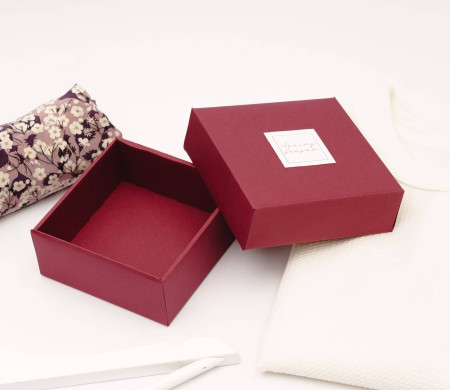 Small, lined burgundy box for organizing personal possessions and clothing.